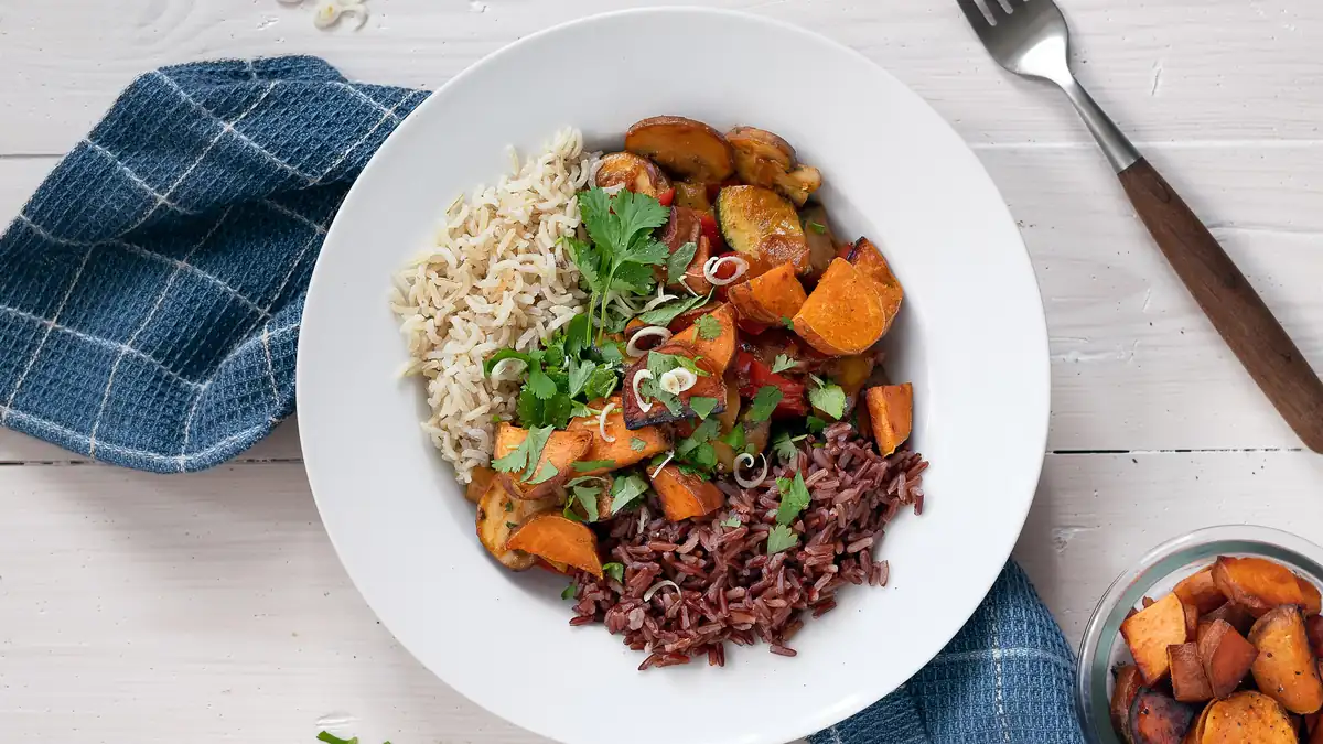 A plate of herby rice with roasted sweet potato, black rice and spring onions